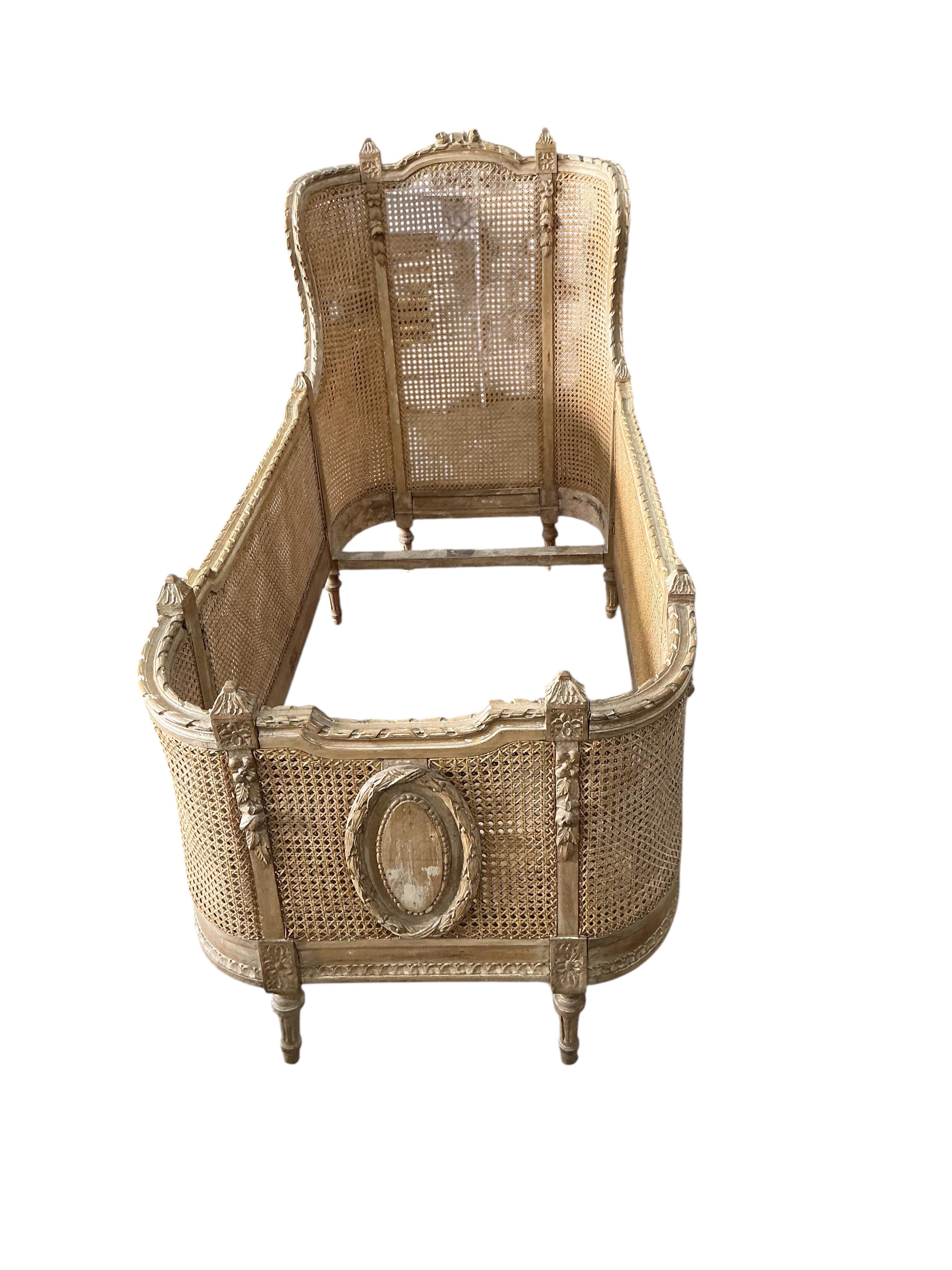 A Louis XVI style caned beech child's bed frame, width 71cm, height 105cm